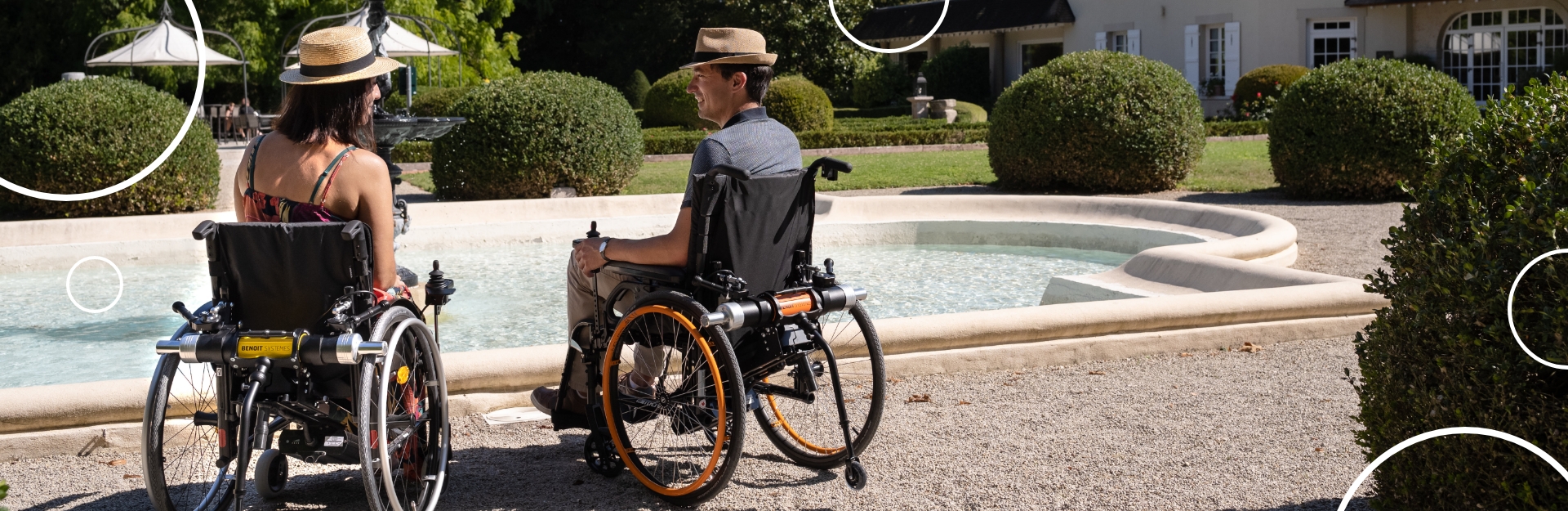 Une femme et un homme dans un fauteuil roulant au bord d'une fontaine. 