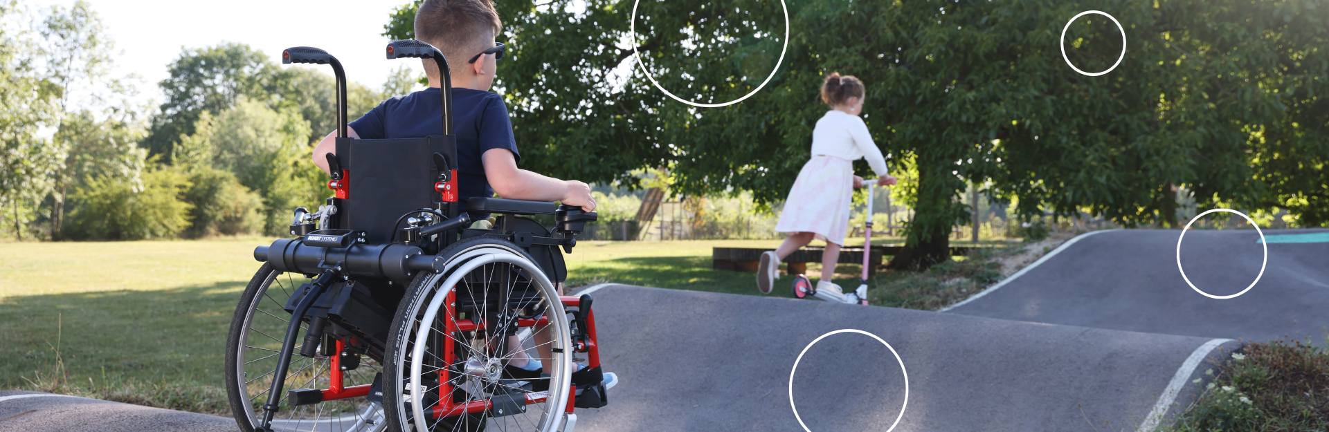 Un jeune garçon sur un fauteuil roulant avec une motorisation Minotor de Benoit Systemes. 