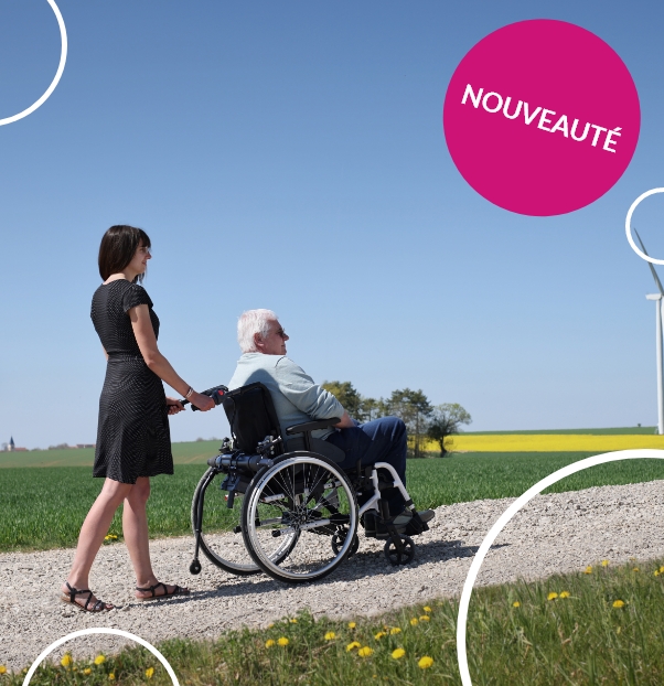 Enfant qui se promène dans un parc en fauteuil roulant avec une motorisation Mini Minotor 2.1de Benoit Systemes. 